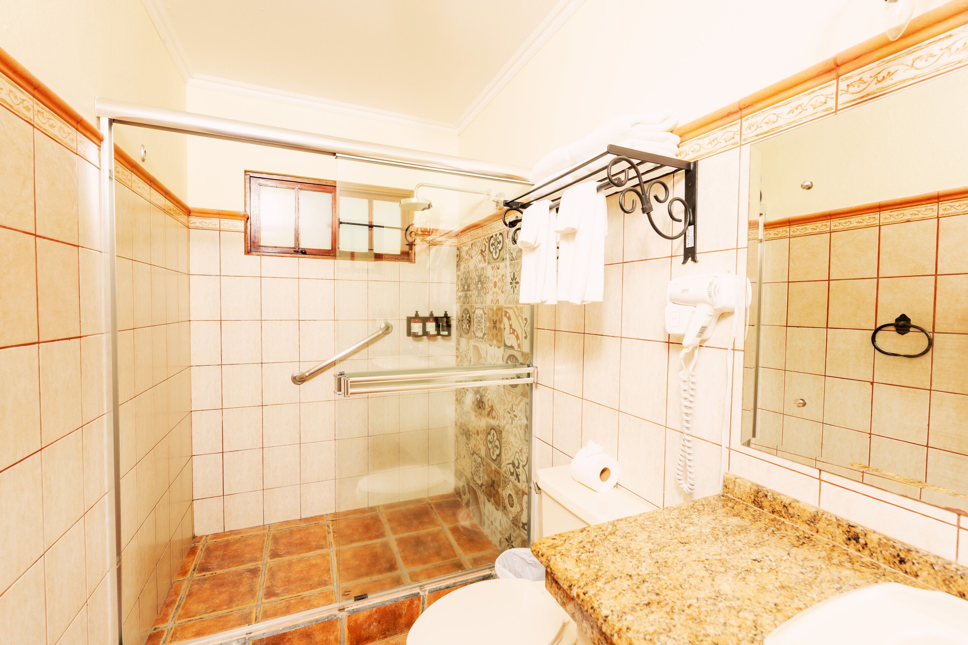 Un baño con ducha, inodoro y lavamanos.