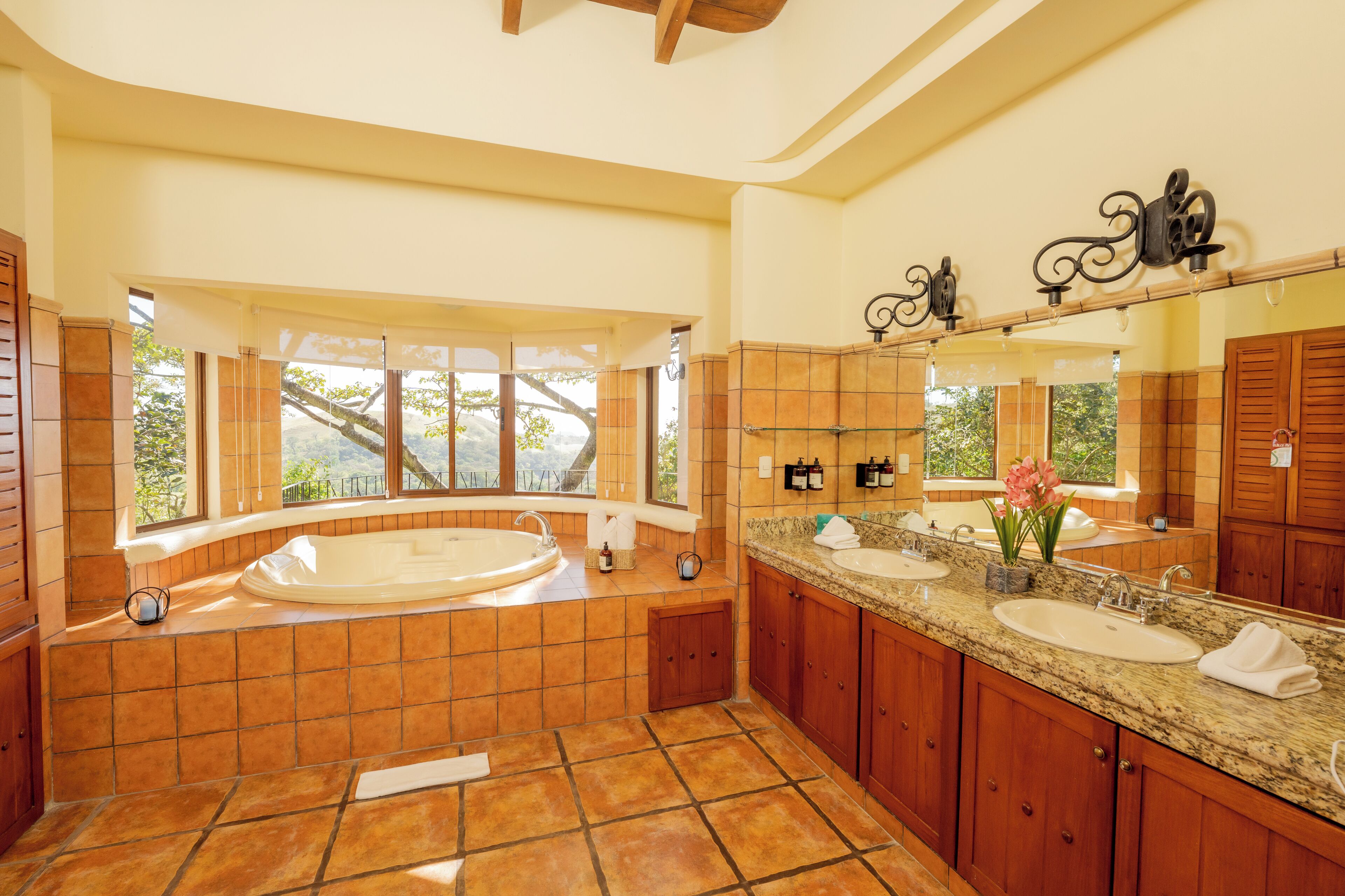 A spacious bathroom with a large bathtub, two sinks, and a vanity area.