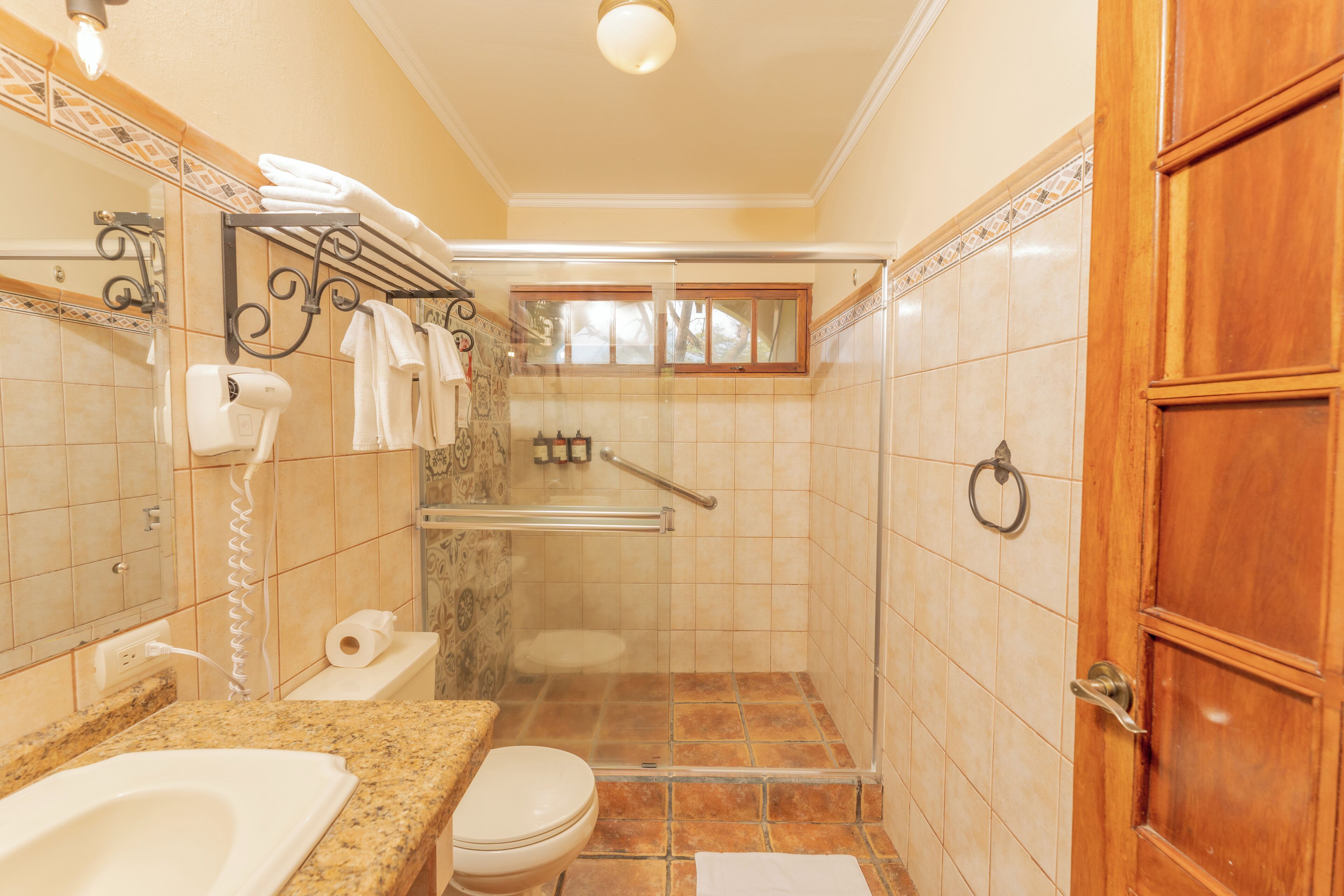 A bathroom with a shower, toilet, and sink.