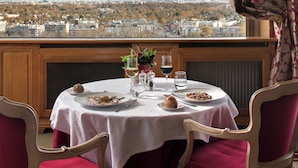 A table set for dining with a city view in the background. - Pavillon Henri IV Hotel Restaurant Gastronomique Terrasse (Saint-Germain-en-Laye)