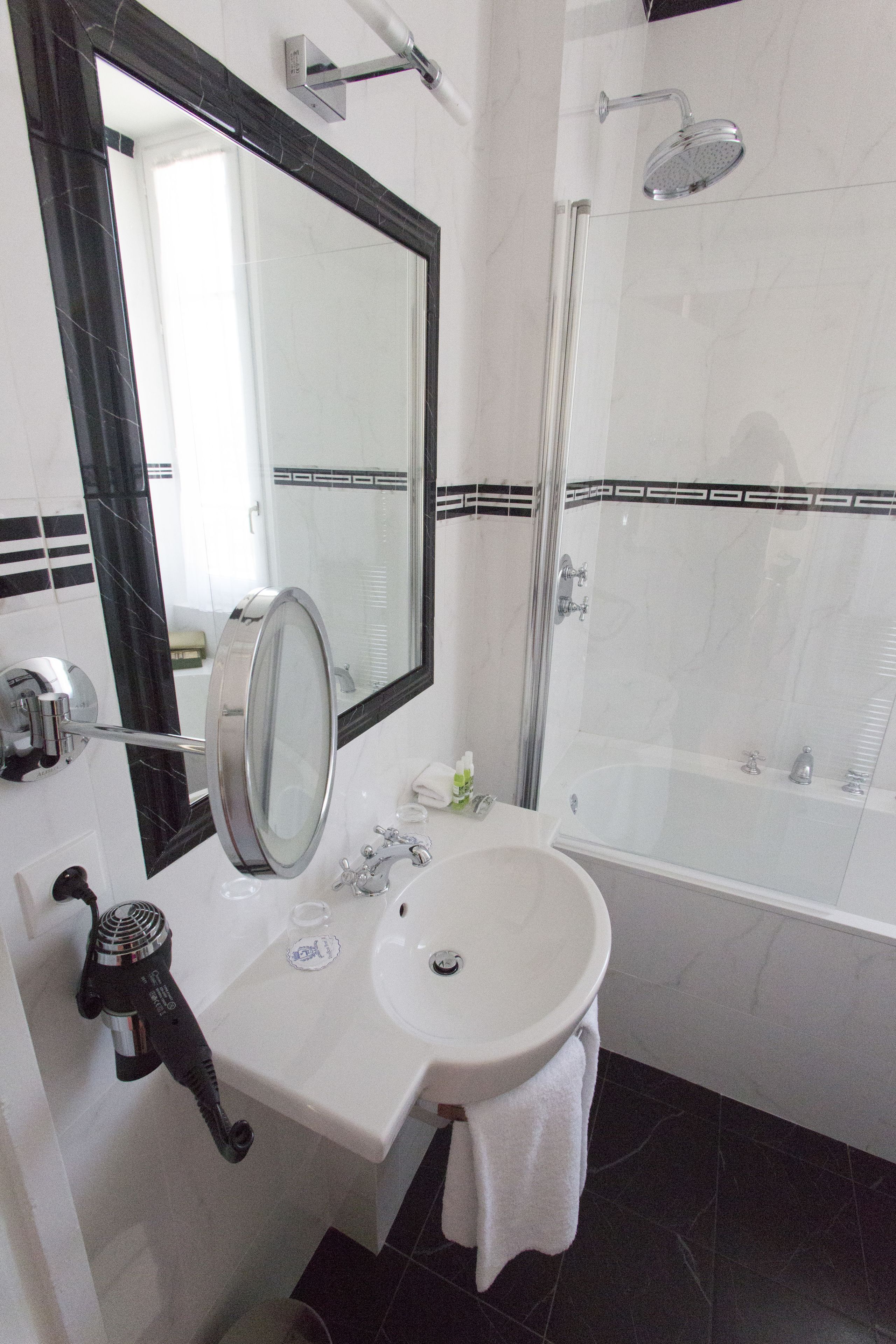 A bathroom with a sink, mirror, and shower.