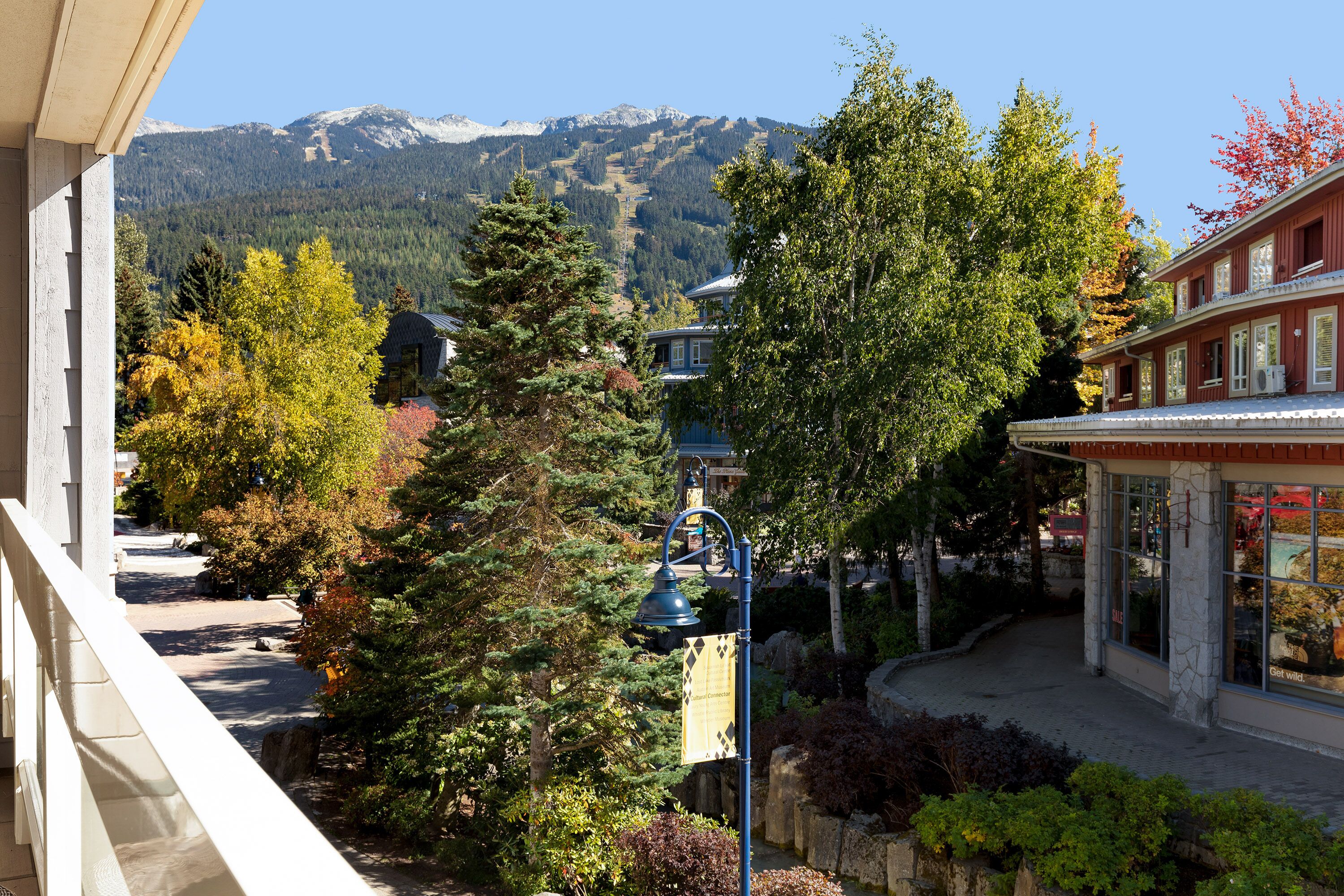 A mountain view with a building featuring a balcony and a street lamp.