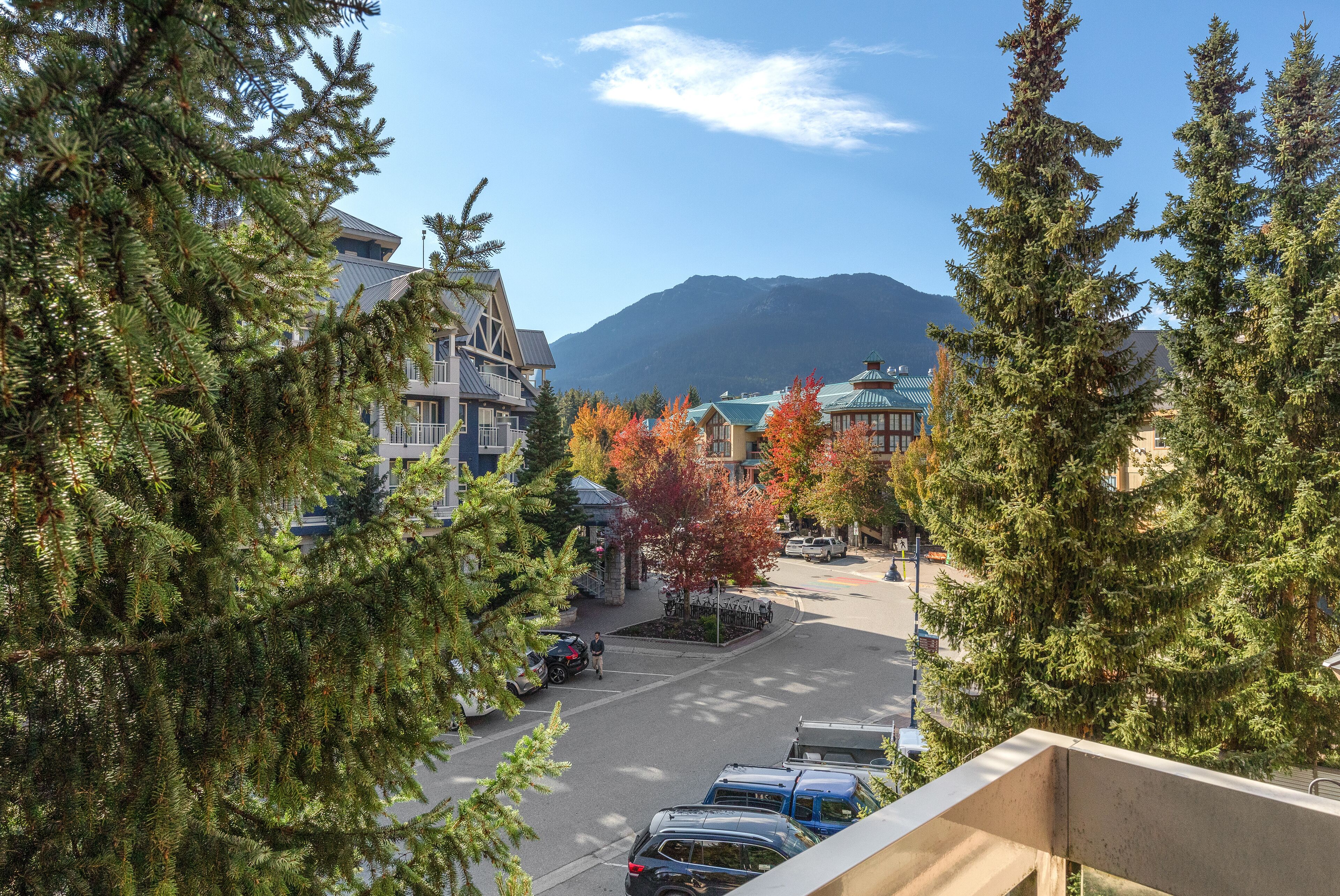 A residential area with houses, a parking lot, and a mountain in the background.