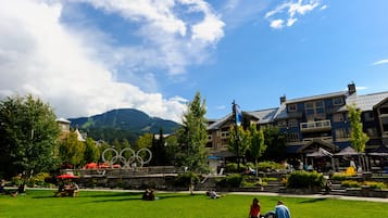 A hotel with a view of mountains, a clock tower, and a large Olympic rings sculpture.
