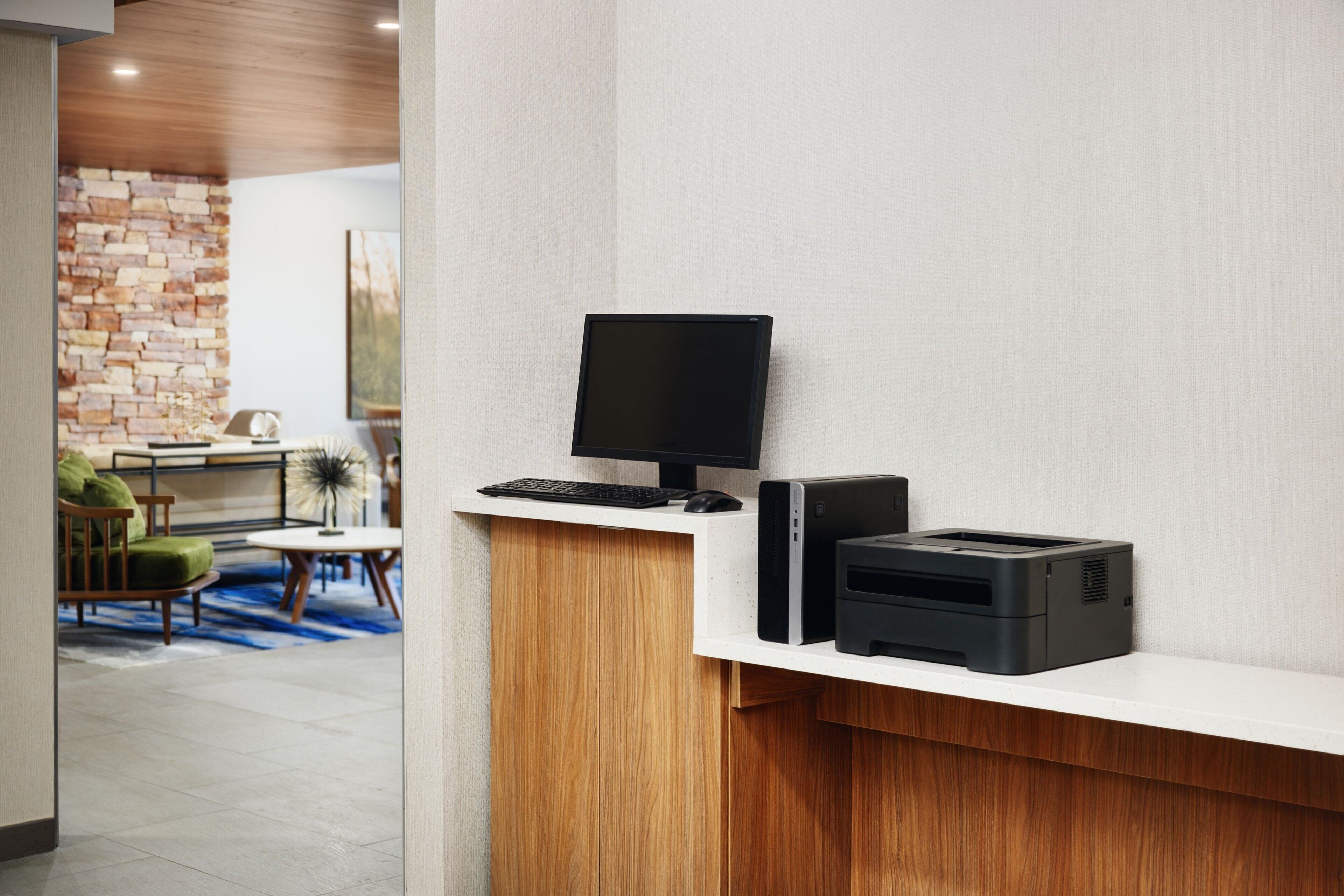 Mostrador de recepción con computadora, impresora y teclado.