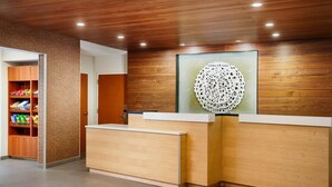 A reception area with wooden paneling and a modern reception desk. - Fairfield Inn & Suites by Marriott Worcester Auburn (Auburn)