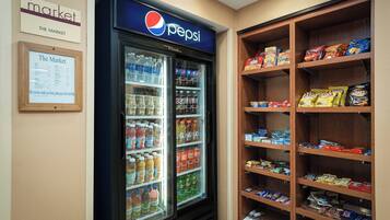 A vending machine stocked with Pepsi and other beverages, and shelves with snacks and other food items.