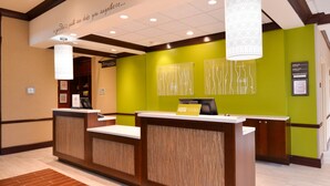 A reception desk with a green wall and a wooden reception area.