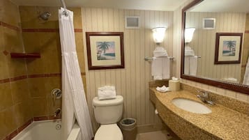 A bathroom with a bathtub, toilet, and two sinks.