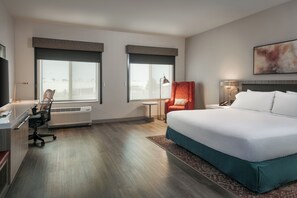 A hotel room with a bed, desk, chair, and a large window. - Hilton Garden Inn Tri-Cities/Kennewick (Kennewick)