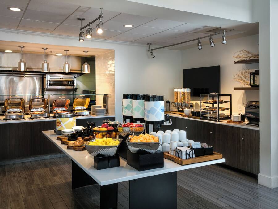 Una cocina moderna con una mesa de buffet, que incluye una estación de café y diferentes opciones de comida.