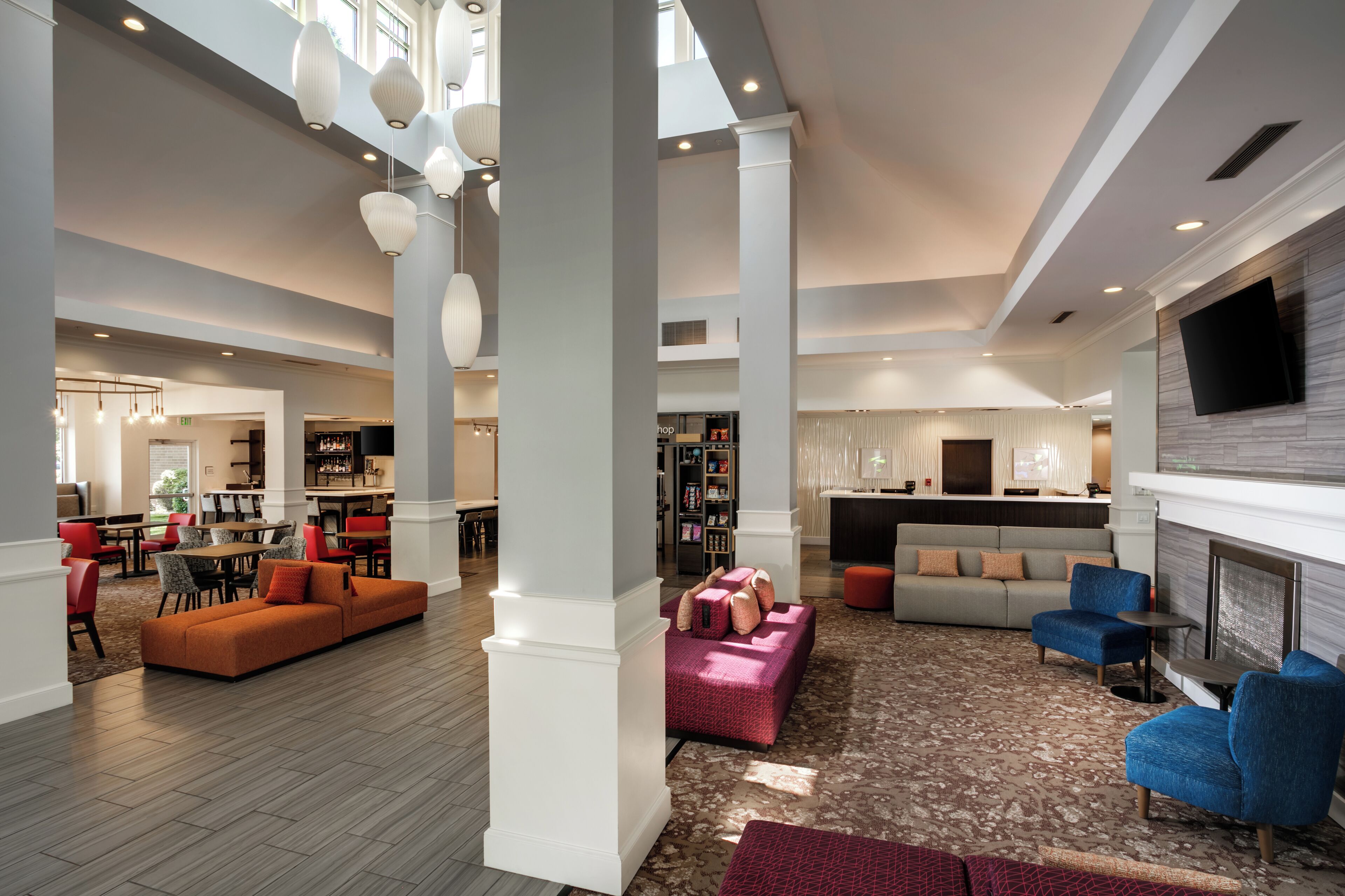 A spacious lobby with a seating area, a bar, and a fireplace.