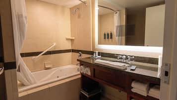A modern bathroom with a bathtub, a vanity with a mirror, and a shower area.