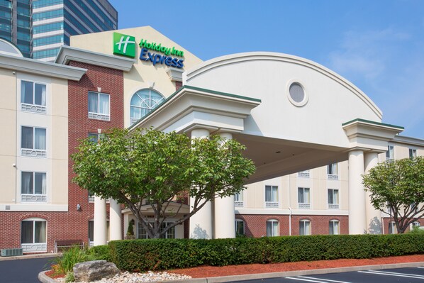 A Holiday Inn Express hotel with a brick facade, large windows, and a covered entrance area. - Holiday Inn Express Tower Center by IHG (East Brunswick)
