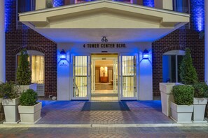 A hotel entrance with a brick facade, a sign reading "4 Tower Center Blvd.", and a set of double doors. - Holiday Inn Express Tower Center by IHG (East Brunswick)