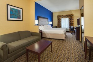 A hotel room with a bed, a sofa, a desk, and a framed picture on the wall. - Holiday Inn Express Tower Center by IHG (East Brunswick)