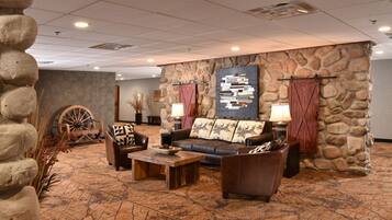A lobby with a stone wall, a wooden bench, a sofa, and a coffee table.