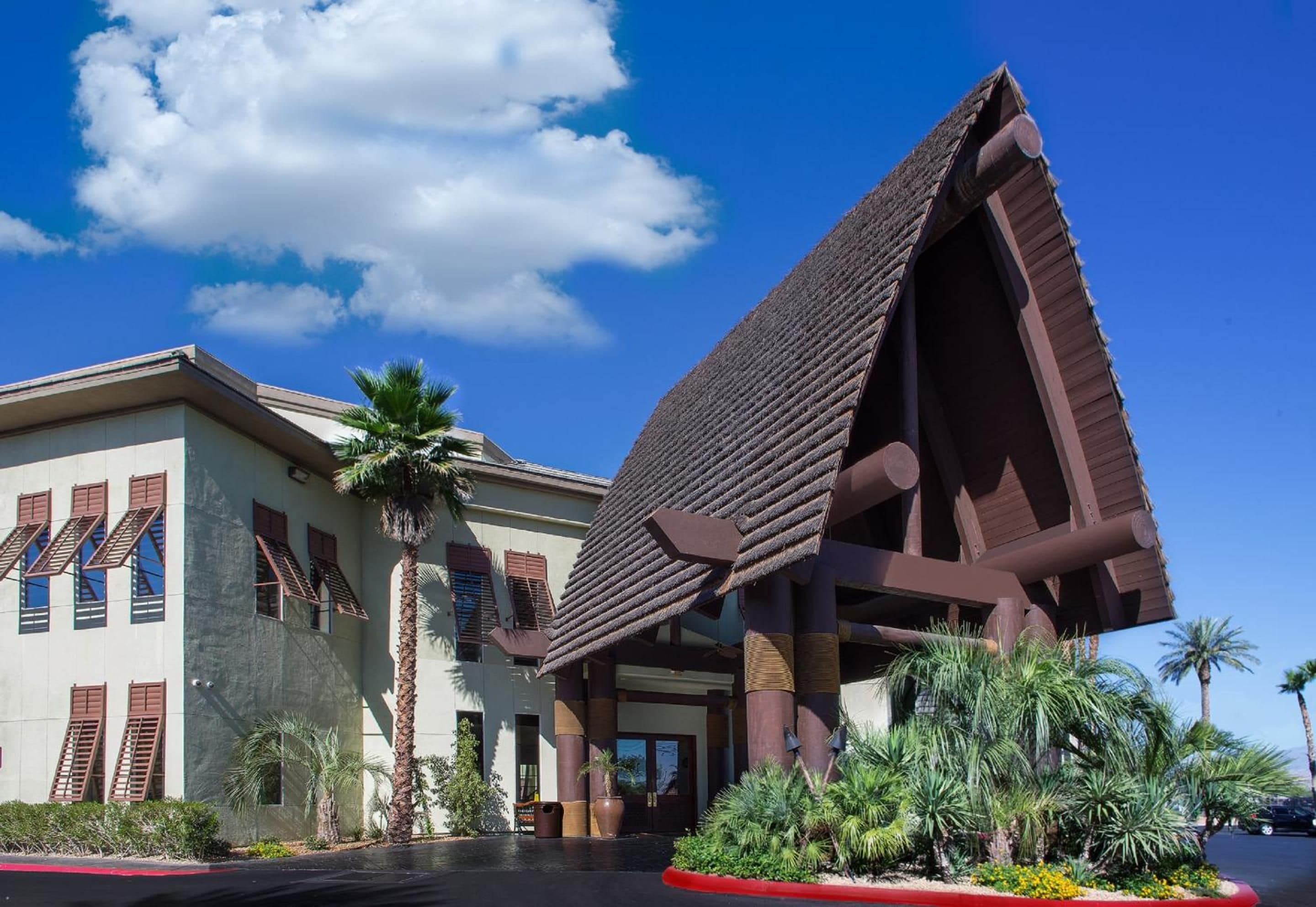 A building with a unique architectural design featuring a prominent triangular roof structure and a modern facade with large windows and shutters.