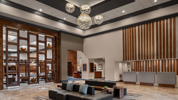 A spacious lobby with a reception desk, seating area, and decorative elements. - Cleveland Marriott East (Warrensville Heights)
