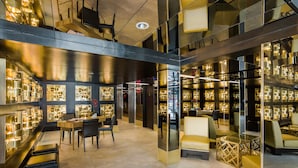 Un intérieur moderne avec un espace salon central, des vitrines et un plafond haut avec des poutres apparentes.