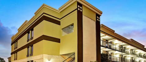 Un hotel de diseño moderno, con una escalera destacada, varios balcones y fachada de ladrillo.