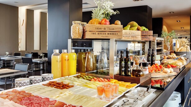 Un'area buffet con diversi cibi, tra cui frutta, verdura e bevande.