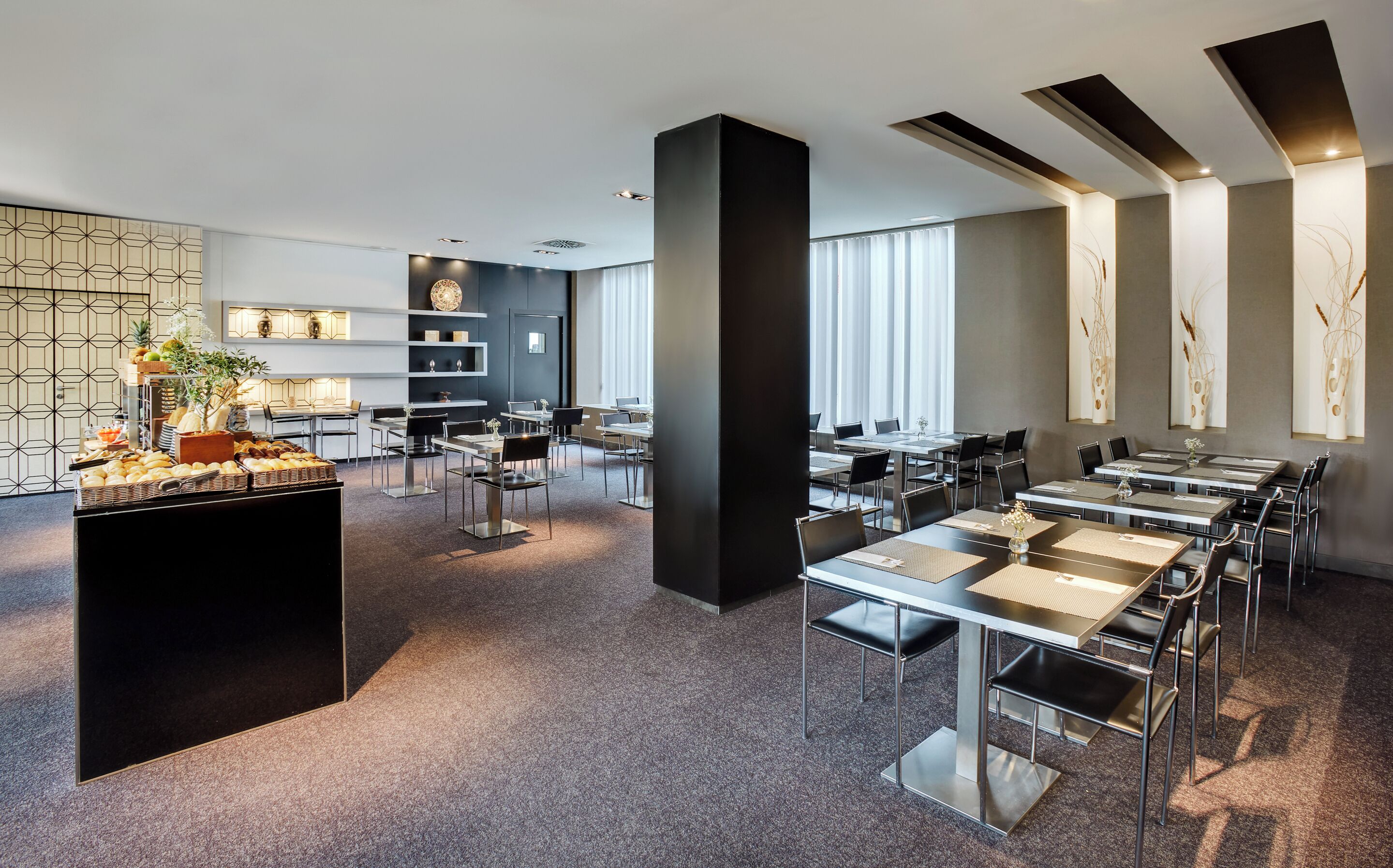 Een moderne hotel lobby met een buffetgedeelte, zithoekjes en decoratieve muurkunst.