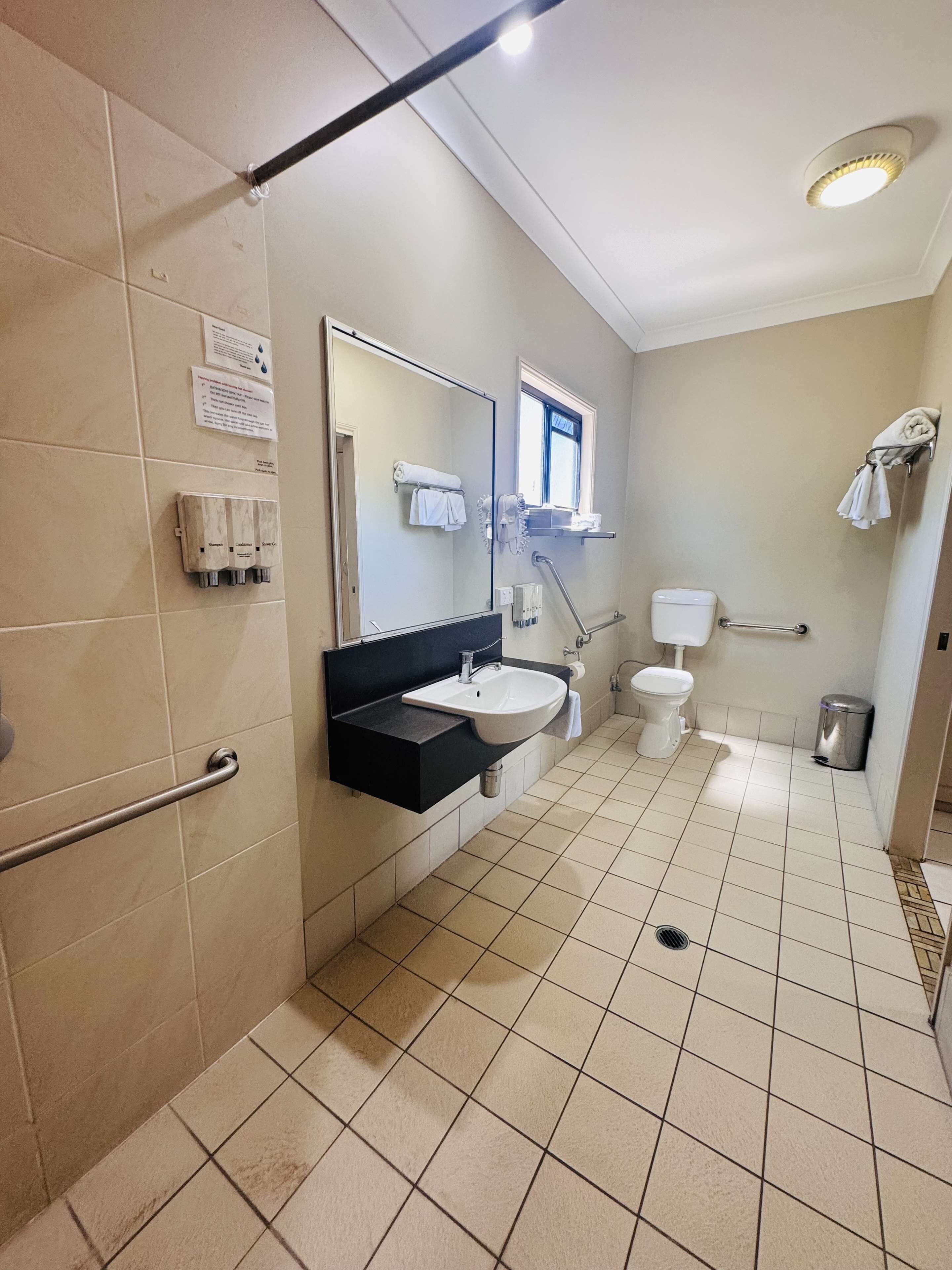 A bathroom with a shower, toilet, and sink.