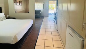 Ett hotellrum med en säng, ett skrivbord och en garderob.