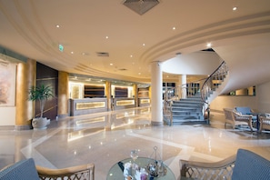 A spacious lobby with a reception desk, a staircase, and seating area. - Swiss Inn Resort Hurghada - All Inclusive (Hurghada)