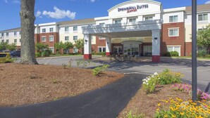 En hotelindgang med et overdækket gangareal, murstensfacade og et skilt med teksten "SpringHill Suites".