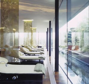 A modern spa with reclining chairs, large windows, and a view of a river. - The G Hotel and Spa (Galway)