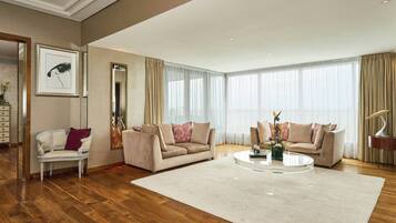 A spacious living room with a large window, a round coffee table, and two sofas.