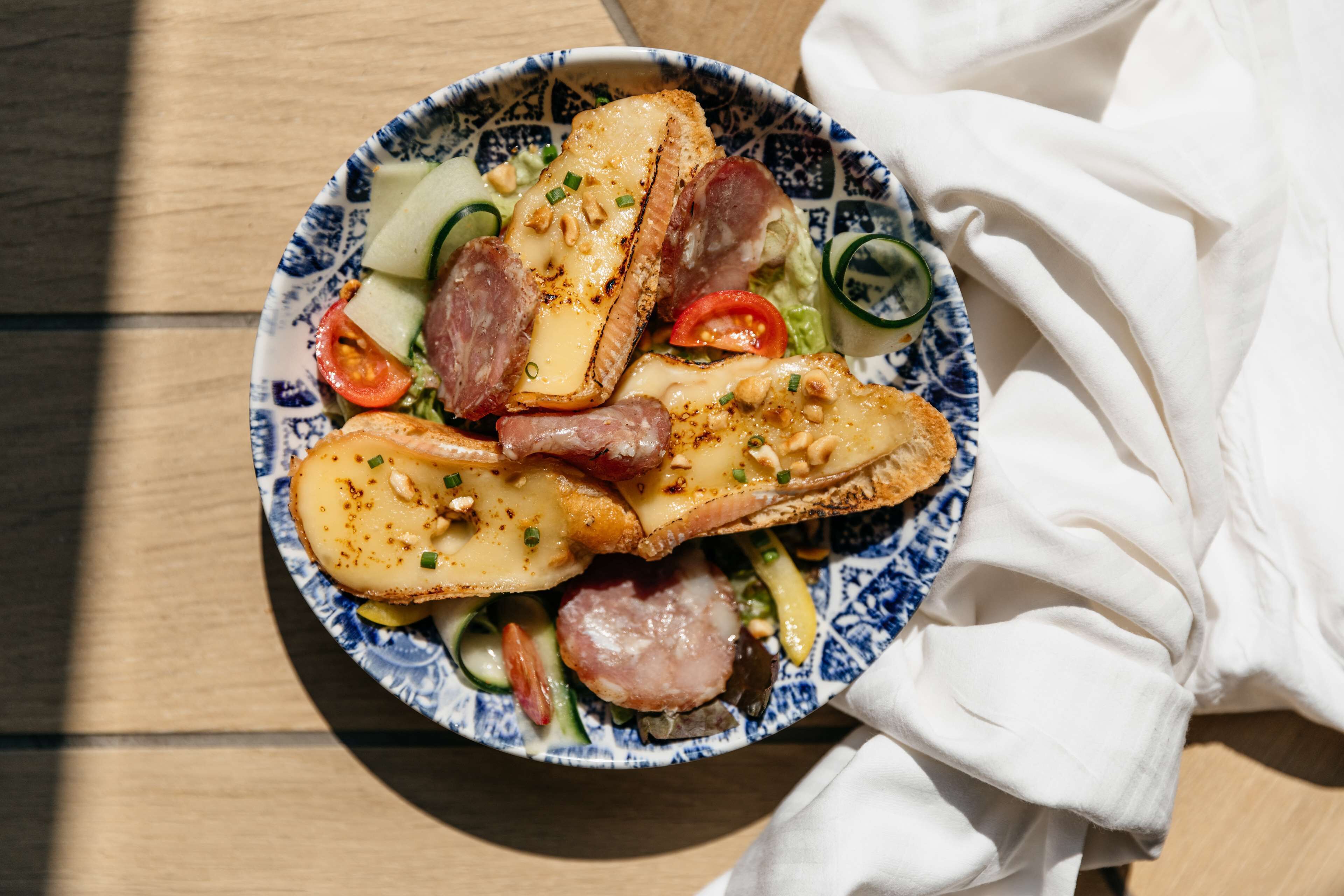 A plate of food with various items including bread, cheese, and vegetables.