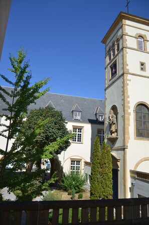 A historic building with a clock tower, arched windows, and a statue. - Hotel Kyriad Metz Centre (Metz)