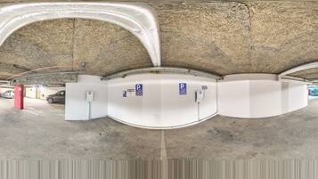 An underground parking garage with concrete walls, metal beams, and a ceiling covered in insulation.