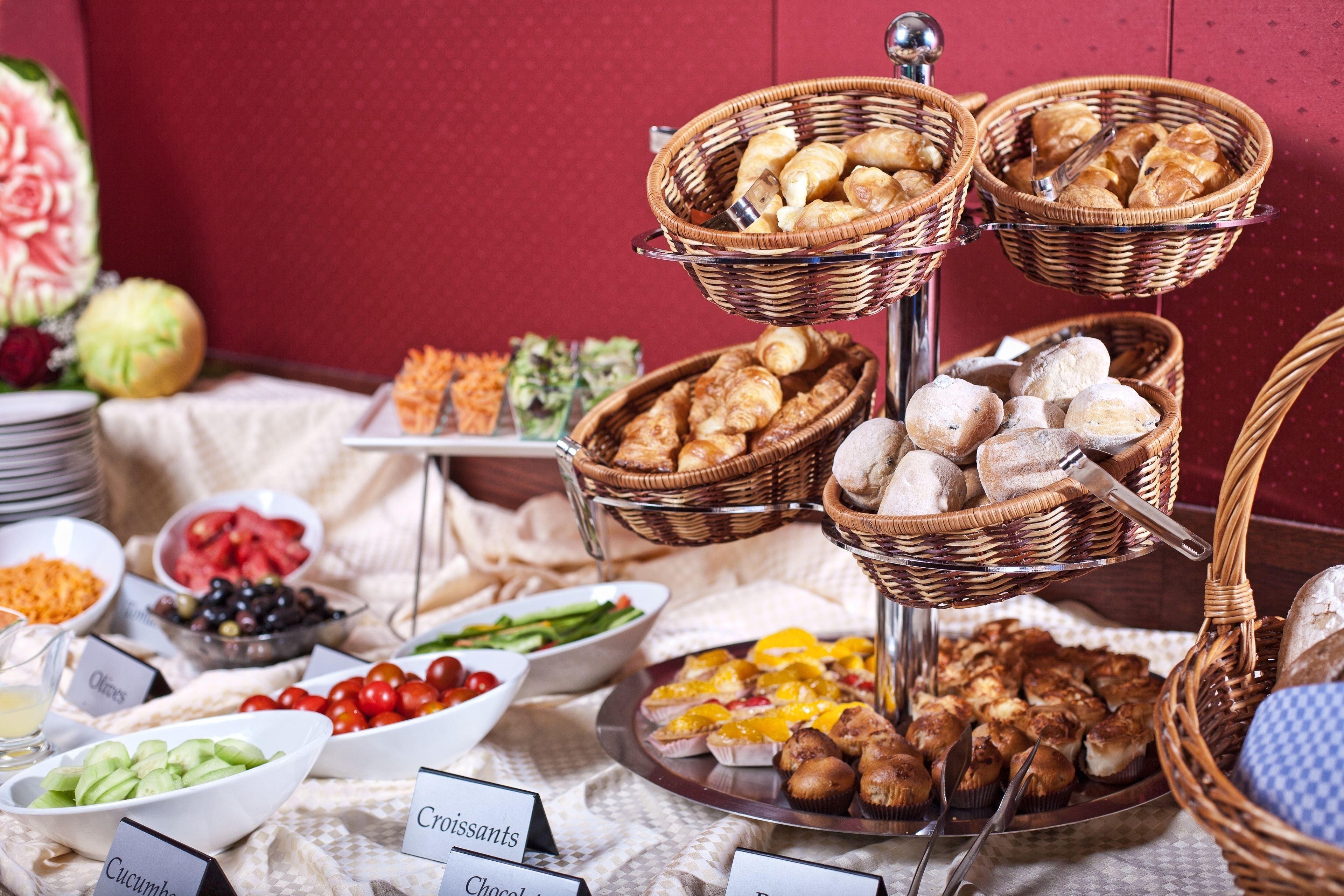 A buffet with various food items including bread, pastries, and vegetables.