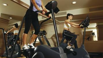Un gimnasio con bicicletas estáticas y suelo de madera.