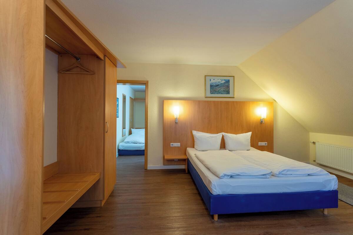 Una camera da letto con un letto, un'armadietto in legno e un comodino.
