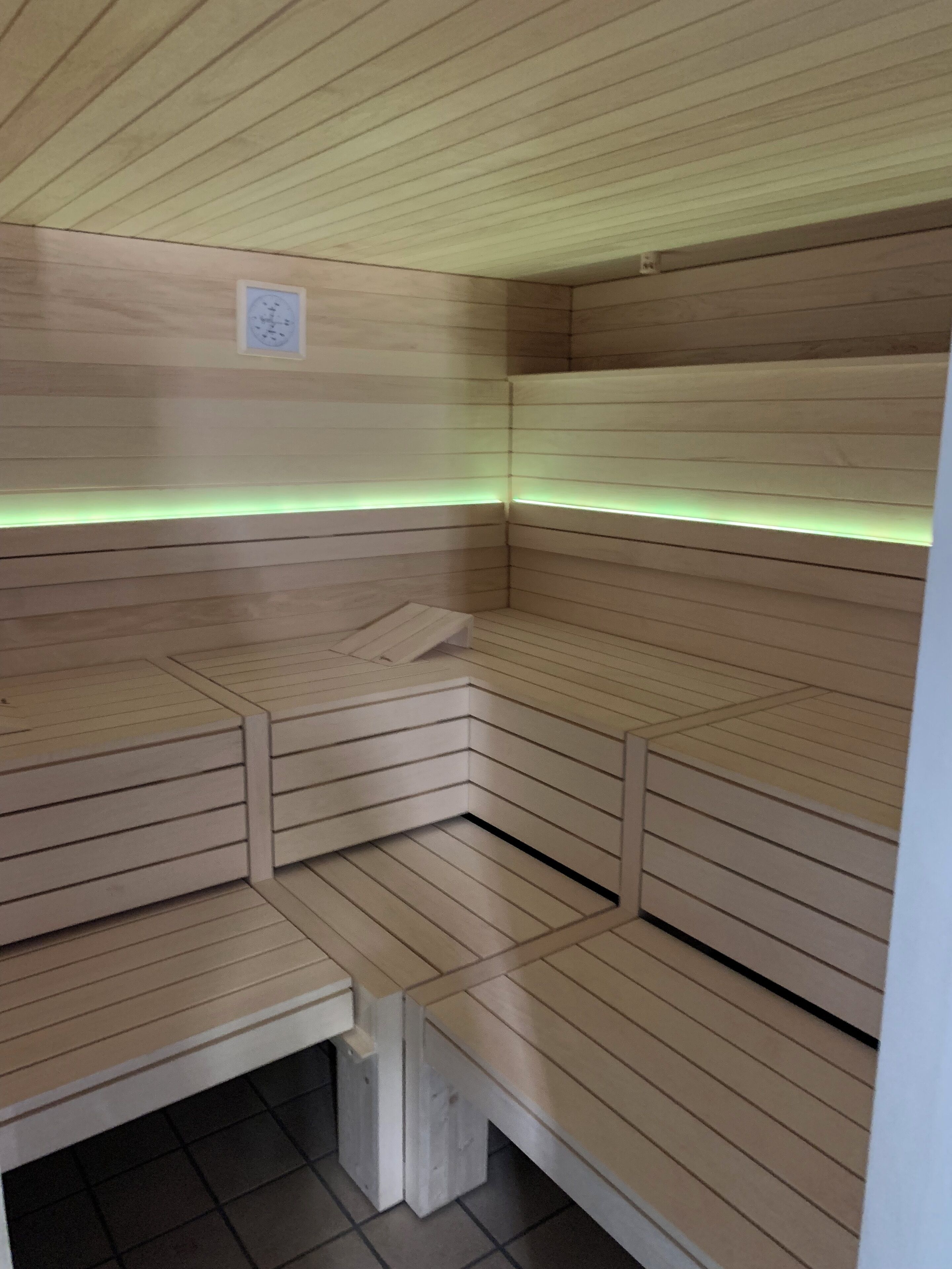 A sauna with wooden benches and a sloped ceiling.