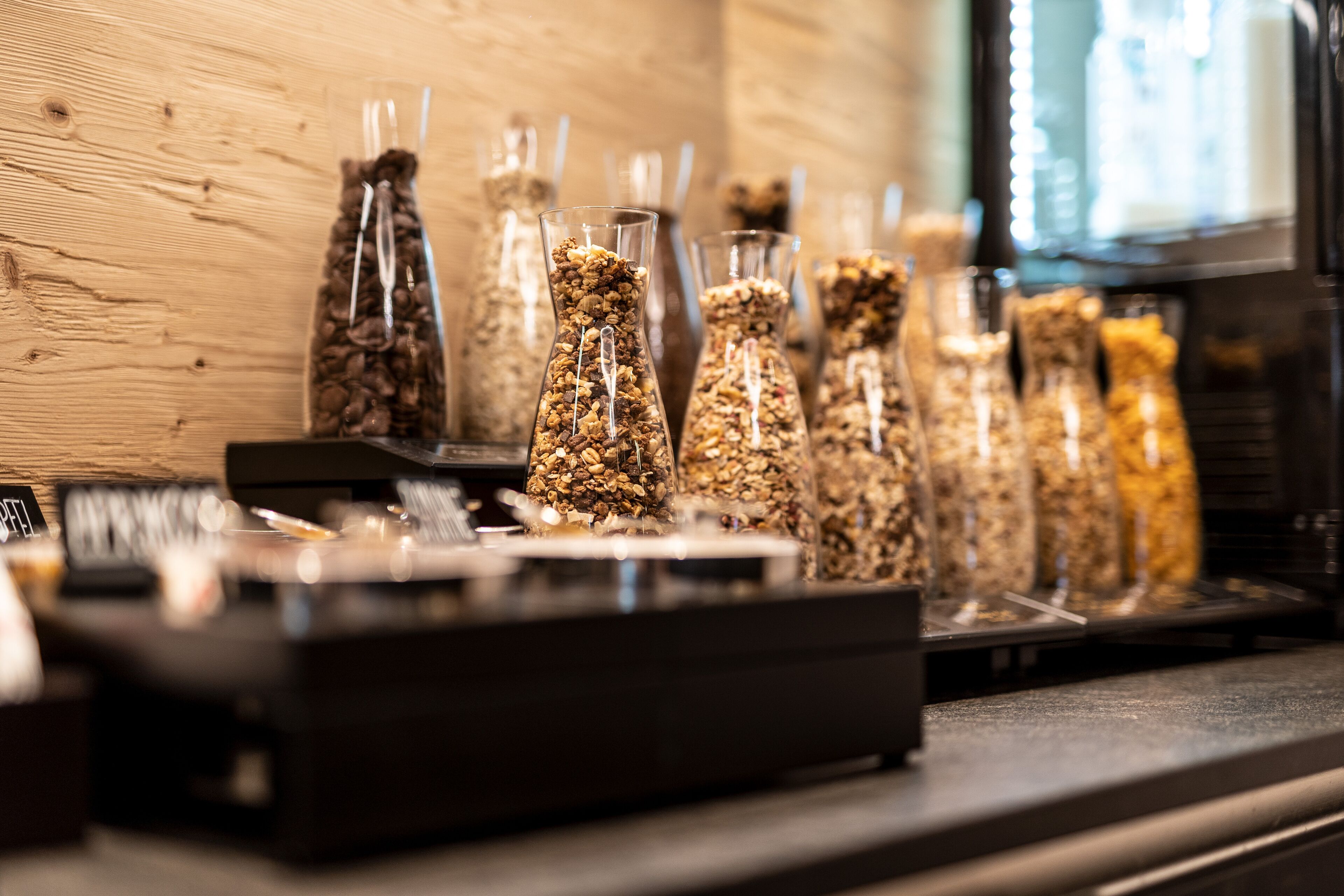 Ein Tresen in einem Café, mit verschiedenen Gläsern mit Granola und Kaffeebohnen.