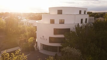 Ein modernes, mehrstöckiges Hotel mit geschwungener Fassade, großen Fenstern und einem gut sichtbaren Schild mit der Aufschrift 'BLOCK HOTEL & LIVING'.