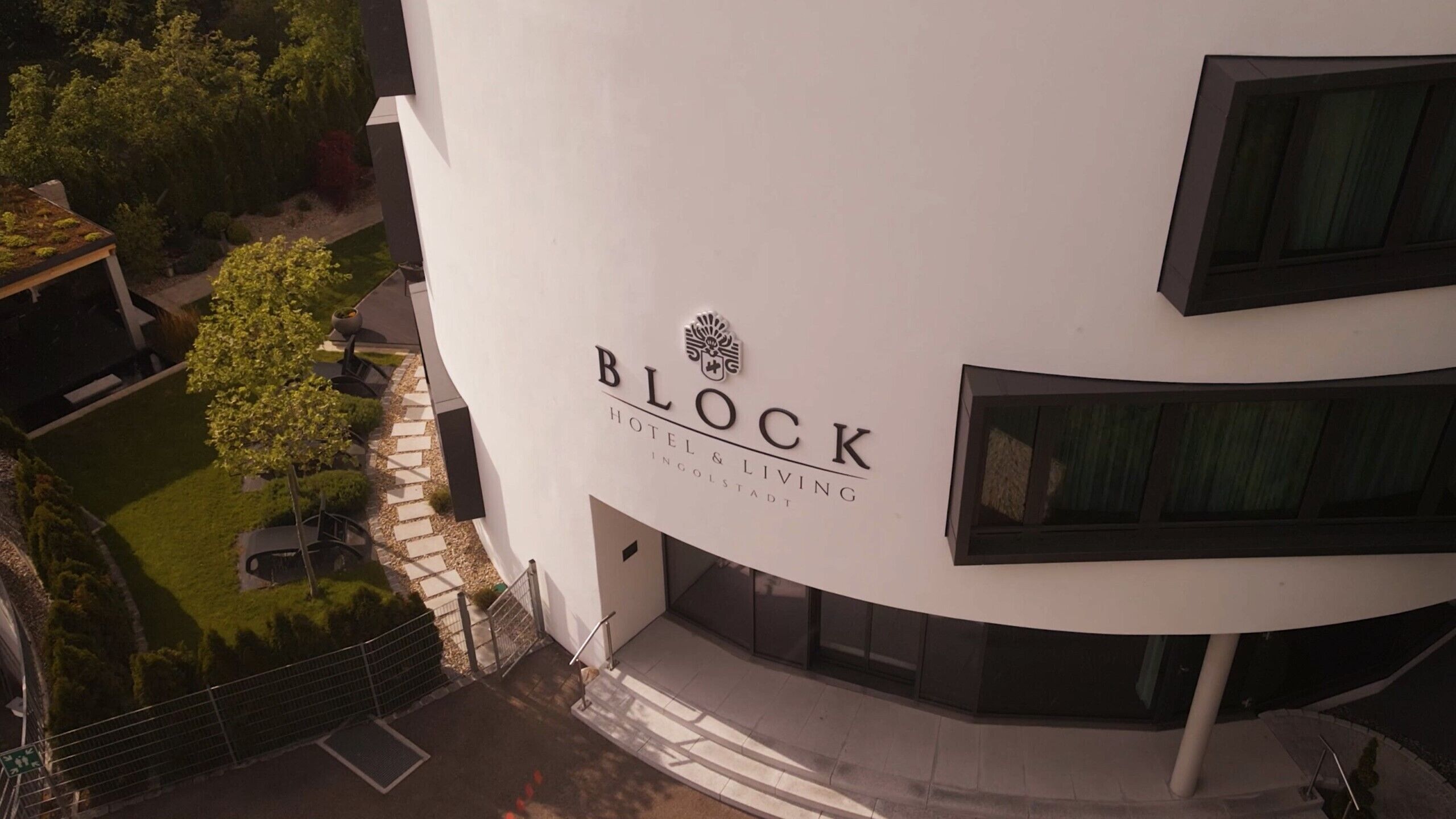 A modern hotel building with a sign reading "BLOCK HOTEL & LIVING INGOLSTADT".