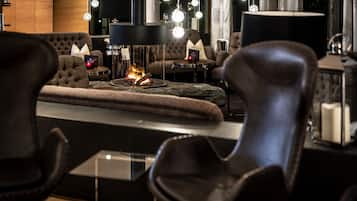 A cozy lounge area with a fireplace, comfortable seating, and ambient lighting.