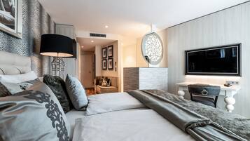 Una habitación de hotel moderna con una cama grande, un escritorio y una televisión.