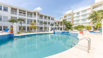 Een buitenzwembad, parasols bij het zwembad en ligstoelen