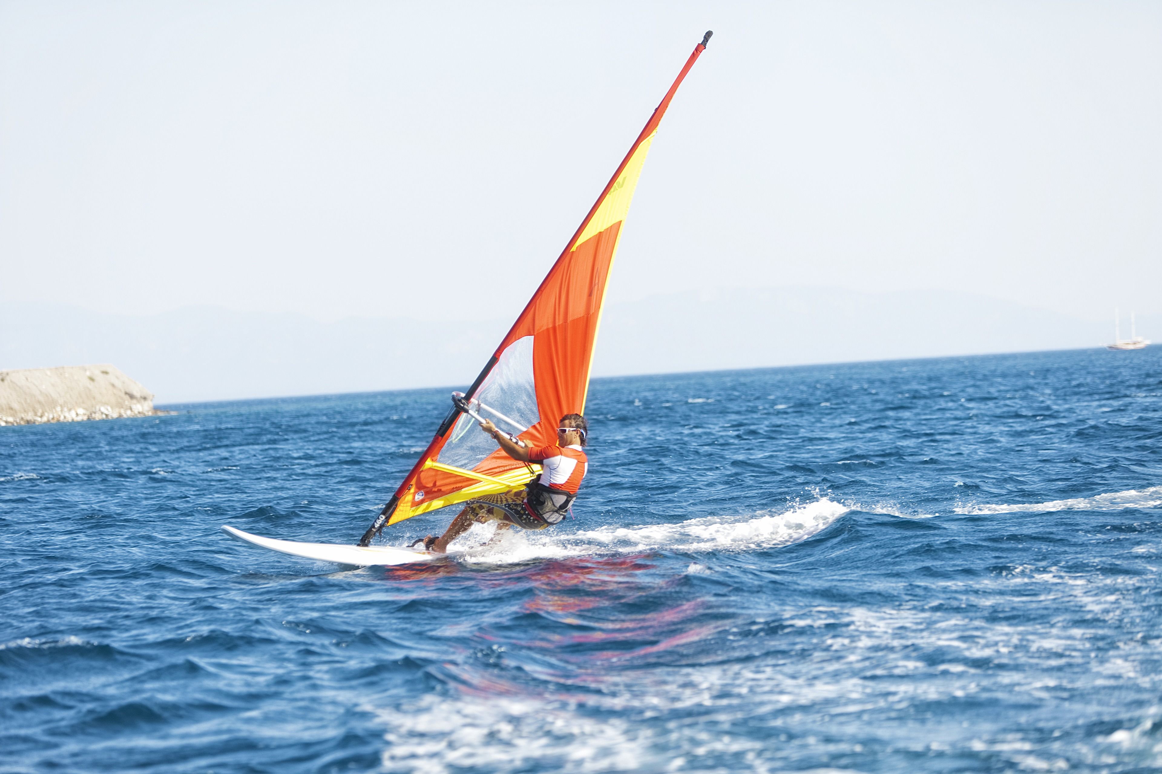 Une personne pratiquant la planche à voile par temps clair.
