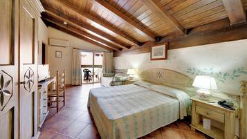 Ein Schlafzimmer mit Bett, Nachttisch, Lampe und Schreibtisch mit Stuhl.