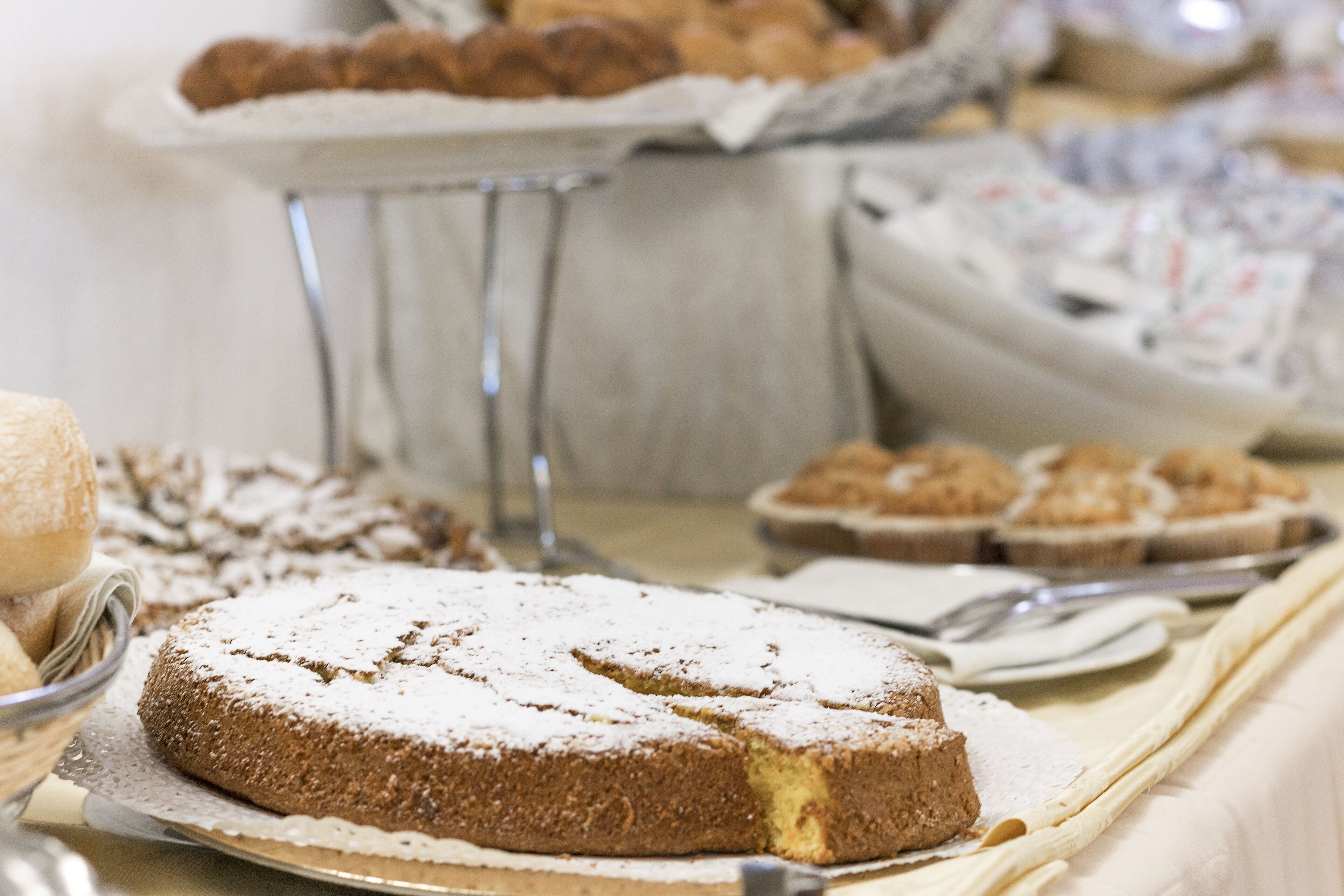 A buffet table with various desserts including a cake and pastries.