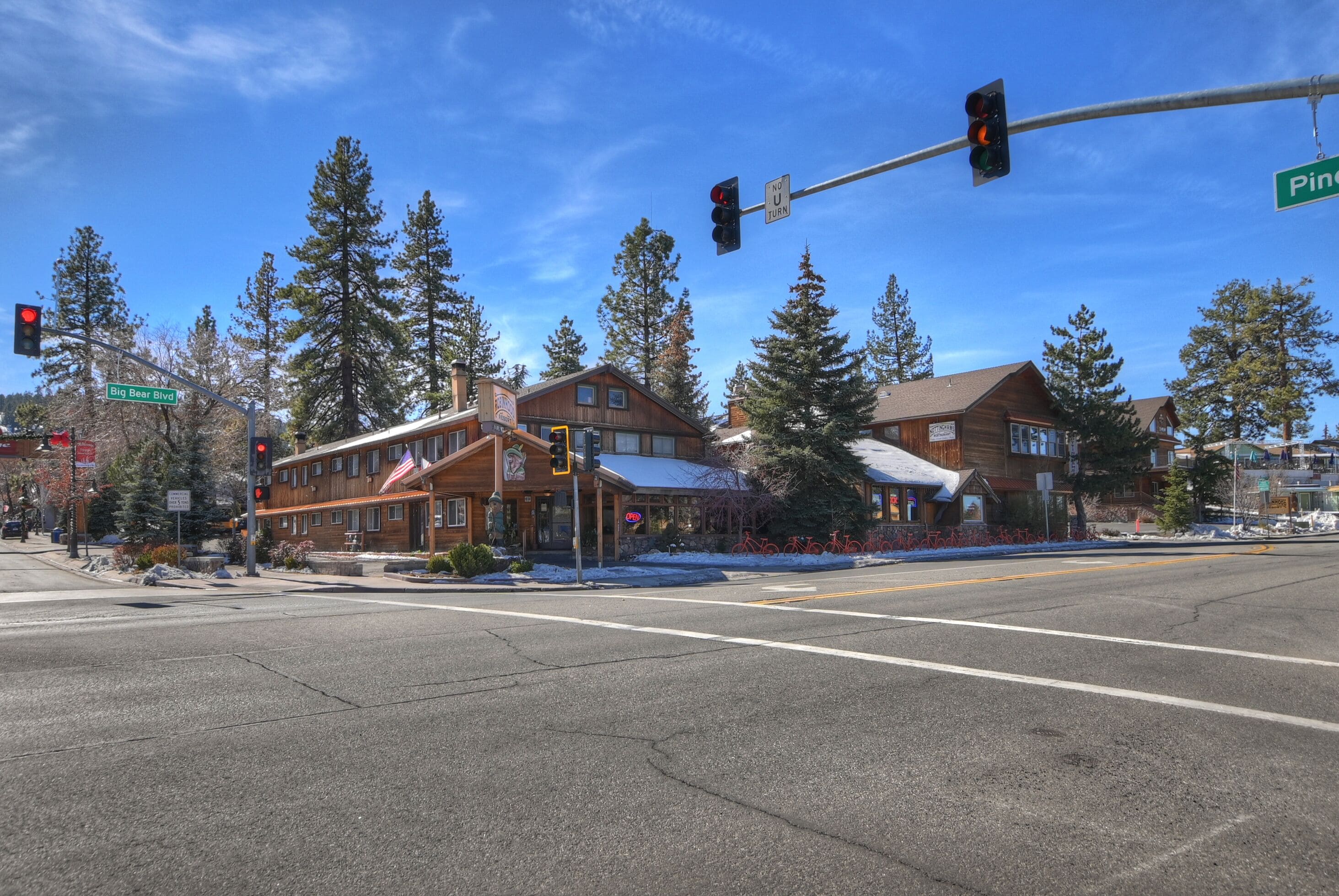 Eine Straßenkreuzung mit Ampel, ein Gebäude mit der Aufschrift 'Big Bear Blvd' und einem Verbotsschild für Wenden.